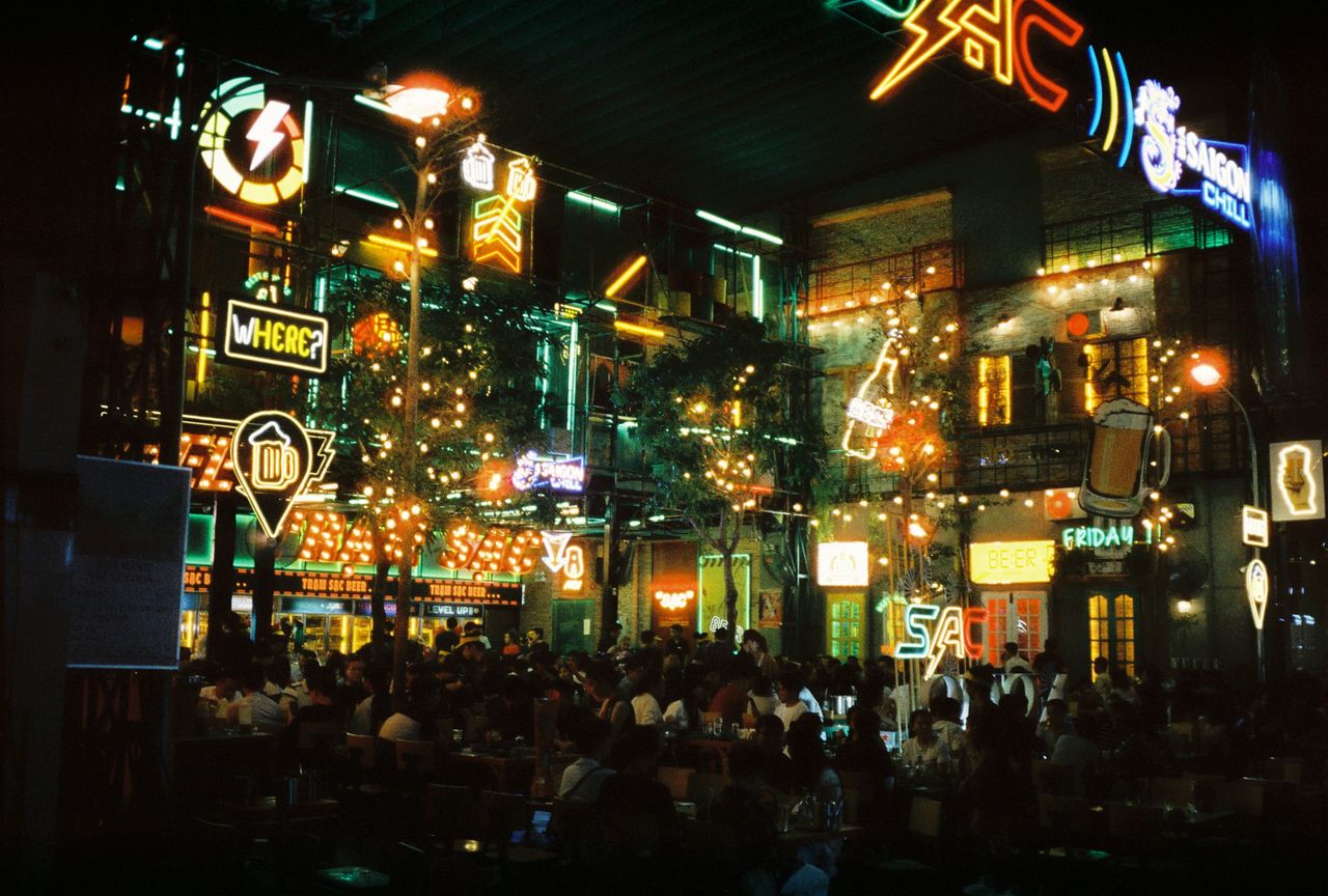 Lively nightlife featuring neon signs and a crowded bar, capturing the energy of the night.