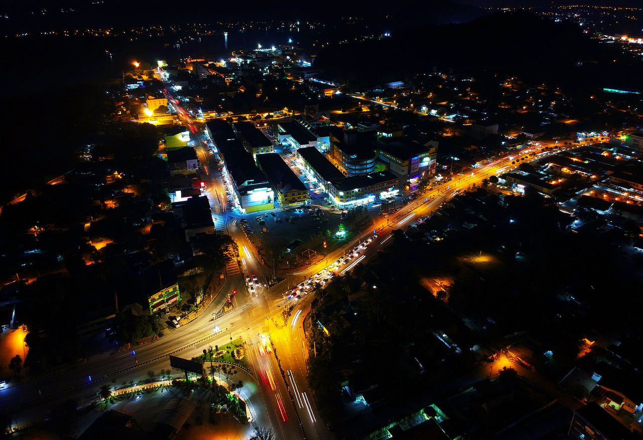 Stunning aerial view of a vibrant cityscape at night with bright lights and bustling streets.